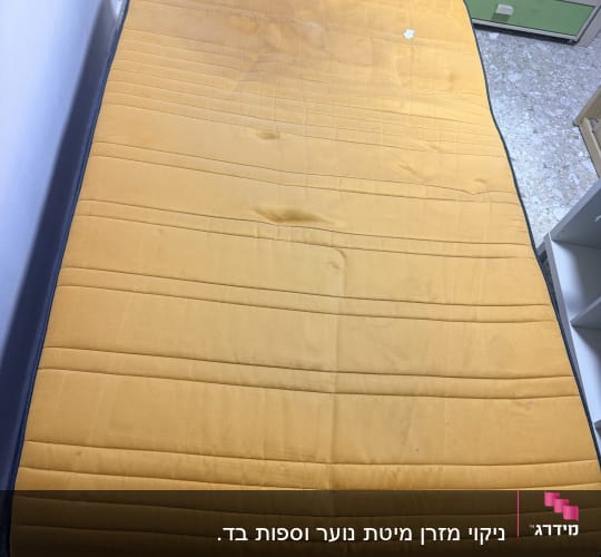 מזרן בד צהוב עם כתמי לכלוך לפני או במהלך ניקוי מזרנים